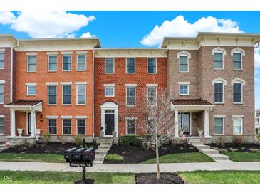 Beautiful brick townhomes feature manicured lawns, landscaping, and inviting front porches for curb appeal at 2627 Congress St, Carmel, IN 46032