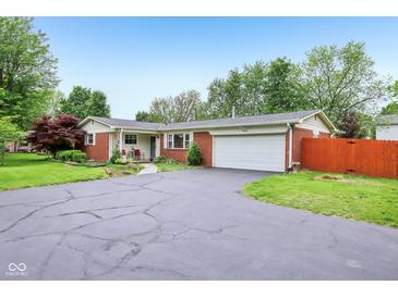 Charming brick ranch home with an attached two-car garage and beautiful landscaping at 2910 S Sheridan Ave, Indianapolis, IN 46203