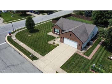 Aerial view of a brick single-Gathering home with a driveway, well-maintained lawn, and mature trees in a suburban neighborhood at 401 Paddlebrook Dr, Danville, IN 46122