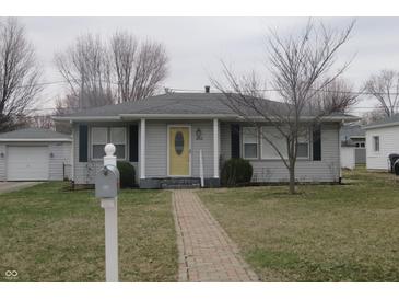 Charming one-story home with a brick walkway and a bright yellow front door, complemented by a tidy front yard at 406 W Jackson St, Alexandria, IN 46001