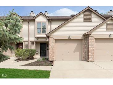 Inviting townhome featuring an attached garage, neutral siding and nicely manicured landscaping at 7208 Long Boat Dr, Indianapolis, IN 46250