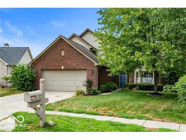 Charming two-story brick home with a well-manicured lawn and mature trees at 10934 Haig Point Dr, Fishers, IN 46037