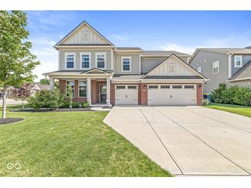 Charming two-story home with a three-car garage, manicured lawn, and inviting front porch at 11003 Liberation Trce, Noblesville, IN 46060