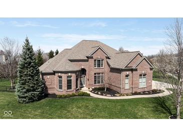Stunning brick home featuring a manicured lawn and beautiful landscaping at 13214 Mink Ln, Carmel, IN 46074