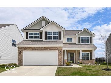 Charming two-story home with a brick and siding exterior, attached two-car garage, and a well-manicured front yard at 1455 Bigleaf Dr, Sheridan, IN 46069