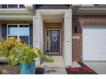 Charming front door with decorative wreath and sidelights, accented by brick and fresh landscaping at 2736 Victory Dr, Columbus, IN 47203