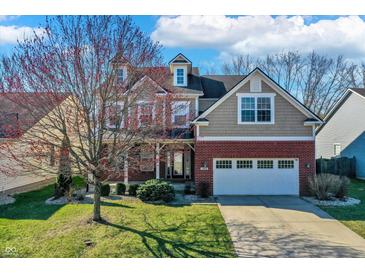 Charming two-story home features a brick facade, dormer, and attached two car garage at 6869 W Winding, McCordsville, IN 46055
