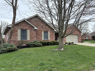 Brick home featuring mature trees, shutters, and an attached garage at 1066 Woodridge, Brownsburg, IN 46112