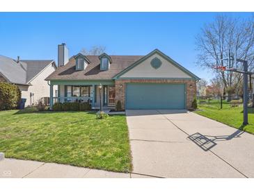 Charming one-story home featuring a two-car garage, inviting front porch, and well-maintained lawn at 10875 Santa Anita Ct, Carmel, IN 46280