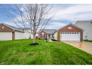 Charming home featuring a brick facade, well-manicured lawn, and attached two-car garage at 12319 Wolf Run Rd, Noblesville, IN 46060