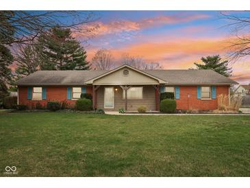 Charming single-story brick home features colorful shutters, landscaped yard, and inviting entrance at 1526 Chapman Dr, Greenfield, IN 46140
