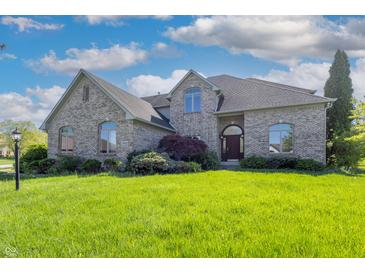 Charming brick home featuring manicured lawn, elegant landscaping, and traditional architectural design at 3256 Waterside Ct, Greenwood, IN 46143