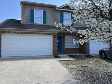 Charming two-story home featuring a brick facade, two-car garage, and blue accents at 4217 Carson Ln, Indianapolis, IN 46227