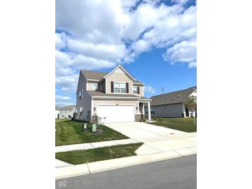 Charming two-story home features neutral siding, black shutters and a two-car garage, set on a well-maintained lawn at 5115 Triple Crown Way, Indianapolis, IN 46237