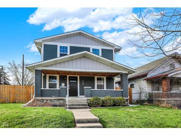 Charming two-story home with a welcoming front porch and well-maintained lawn at 827 E Minnesota St, Indianapolis, IN 46203