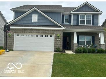 Charming two-story home with a well-manicured lawn and attached two car garage at 9851 Pica Dr, Fishers, IN 46040