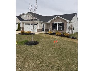 Charming single-story home with a combination of stone and siding and a well-manicured lawn at 99 Gnarled Oak Ln, Whiteland, IN 46184