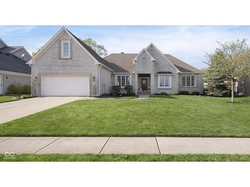 Charming, light brick home with an attached garage and meticulously maintained front yard at 11930 Pebblepointe Pass, Carmel, IN 46033