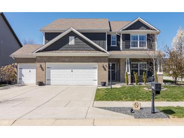 Charming two-story home with a well-manicured lawn, brick accents, and a three car garage at 15493 Kennewick, Noblesville, IN 46062