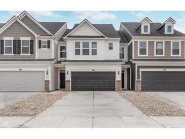 Charming townhome featuring a two-car garage and stone-accented facade, ideal for modern living at 18730 Moray St, Westfield, IN 46074
