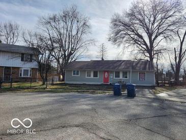 Charming single-story home with a well-maintained lawn and a bright red front door at 3844 Esquire Ct, Indianapolis, IN 46226