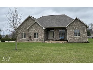 Charming brick home with manicured lawn and inviting front porch seating at 6089 W Hellis Dr, Muncie, IN 47304