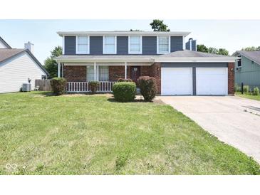 Charming two-story home with a brick and siding exterior and a well-manicured lawn at 7421 Rogers Dr, Indianapolis, IN 46214