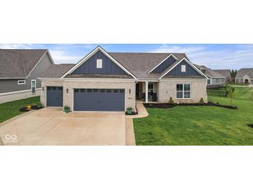 Charming home featuring a two-car garage, a well-manicured lawn, and neutral brick exterior at 11450 Wicker Ln, Noblesville, IN 46060