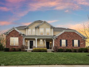 Beautiful two-story home with a brick and siding facade, front porch, manicured lawn, and professional landscaping at 13974 Nina Dr, Carmel, IN 46074