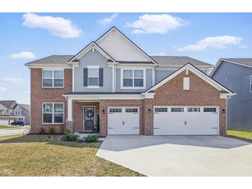 Charming two-story home with brick and siding exterior, a two-car garage, and well-manicured front yard at 3999 Kensington Dr, Danville, IN 46122