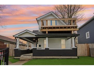 Charming two-story home with inviting front porch and upper-level deck, perfect for outdoor living at 415 S Oxford St, Indianapolis, IN 46201