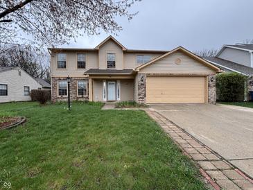 Charming two-story home features a two-car garage, manicured lawn, and inviting curb appeal at 5814 Lakefield Dr, Indianapolis, IN 46254