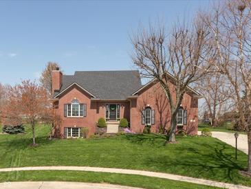 Charming brick home features a well-manicured lawn and mature trees, creating a welcoming curb appeal at 7322 Franklin Parke Ct, Indianapolis, IN 46259