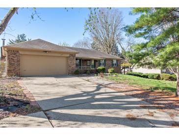 Charming brick ranch with attached two-car garage and well-manicured lawn and professional landscaping at 745 W Banta Rd, Indianapolis, IN 46217