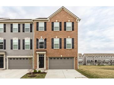 Charming brick-front townhome with a one-car garage and well-maintained landscaping at 17372 Graley Pl, Westfield, IN 46074