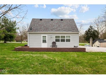 Backyard of home featuring neutral siding, a chair on the deck, and a well-manicured lawn at 218 Urban St, Danville, IN 46122
