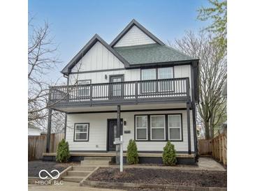 Two-story home with black and white trim, a second-story deck, and manicured landscaping at 221 Eastern Ave, Indianapolis, IN 46201