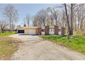 Charming brick home with a spacious yard and long gravel driveway at 4389 S Brooklawn Dr, New Palestine, IN 46163