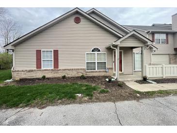 Charming townhouse featuring vinyl siding, red shutters, and brick foundation at 4767 Kelvington Dr, Indianapolis, IN 46254