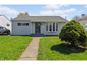 Charming home featuring a well-maintained front lawn, gray siding and an inviting walkway leading to the front door at 5427 E 19Th St, Indianapolis, IN 46218