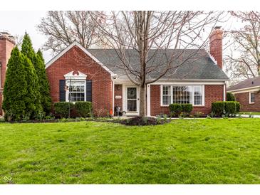 Charming brick home featuring manicured lawn, classic architectural details and a welcoming front entrance at 6041 Garver Rd, Indianapolis, IN 46208
