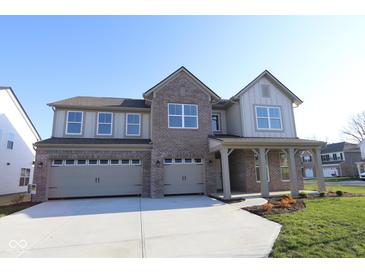 Inviting two-story home featuring a three-car garage, brick accents, and a covered front porch at 10543 Banyan Wood Ct, Indianapolis, IN 46239
