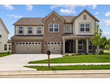Charming two-story home with a brick facade, three-car garage, and well-manicured lawn at 10543 Banyan Wood Ct, Indianapolis, IN 46239