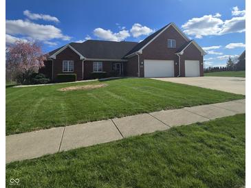 Charming brick home features a two-car garage, manicured lawn, and a blooming tree at 1513 Tottenham Dr, Danville, IN 46122