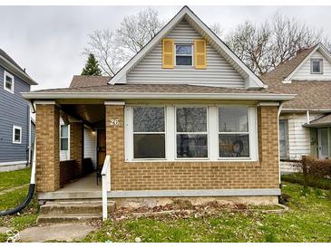 Charming single-Gathering home featuring a brick facade and yellow-shuttered dormer window at 26 N Holmes Ave, Indianapolis, IN 46222