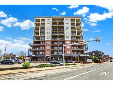 Beautiful condo building with brick and light colored siding, and balconies, under a partly cloudy sky at 435 Virginia Ave # 402, Indianapolis, IN 46203