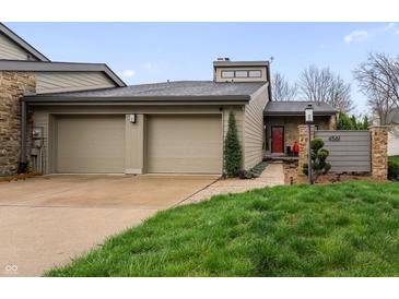 Charming home with a two-car garage, stone accents and well-manicured lawn at 4561 Coles Dr, Columbus, IN 47201