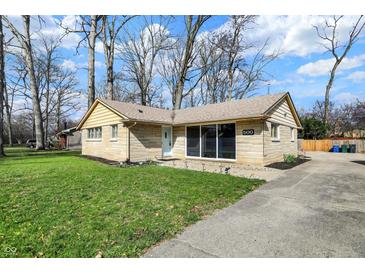 Well-maintained home with a green lawn, mature trees, and a paved driveway leading to the property at 500 N Shellbark Rd, Muncie, IN 47304