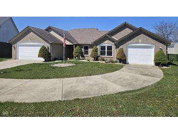 Lovely brick home with manicured lawn, an American flag, and two-car garage at 52 Spring Lake Ct, Trafalgar, IN 46181