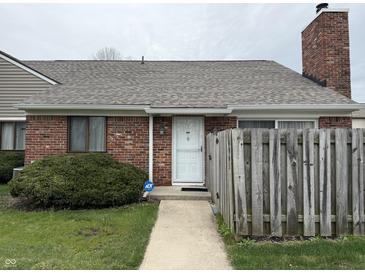 Charming brick home featuring a white front door, well-maintained lawn, and an ADT security system for added peace of mind at 6005 Wingedfoot Ct, Indianapolis, IN 46254